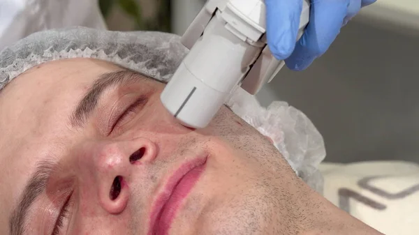 Man getting ultrasound skin treatment at beauty clinic