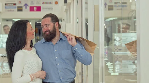 Feliz pareja madura mirando escaparate tienda de ropa en el centro comercial — Foto de Stock