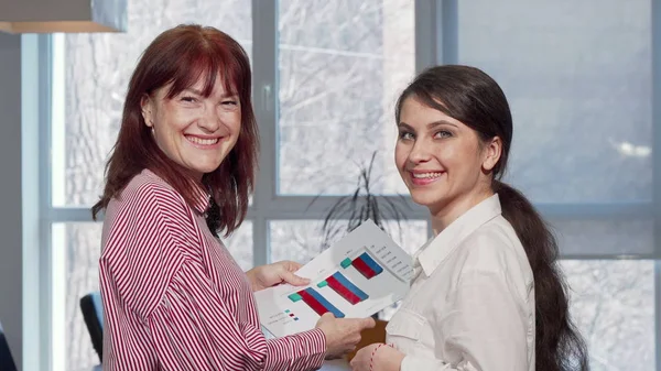 Счастливые деловые женщины улыбаются в камеру, наслаждаются работой в офисе — стоковое фото