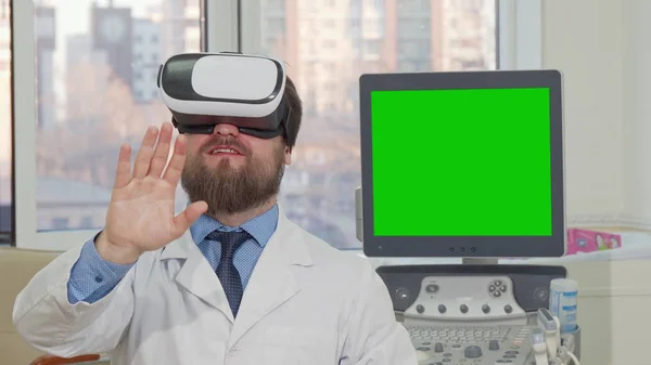 3D VR 안경을 착용 수염 의사, 뒷면에 녹색 화면이있는 컴퓨터 — 스톡 사진