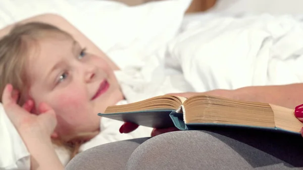 Mãe amorosa lendo conto de fadas para sua filha antes de dormir — Fotografia de Stock