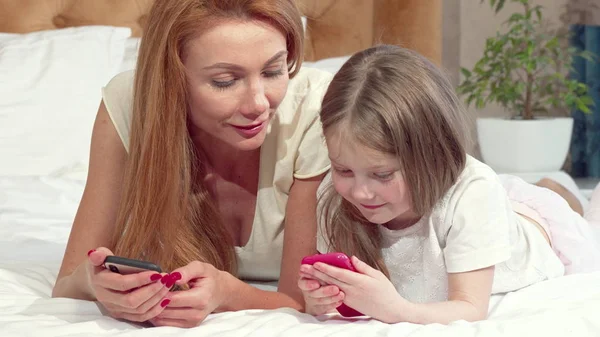 Moeder leert haar dochter met behulp van slimme telefoon — Stockfoto