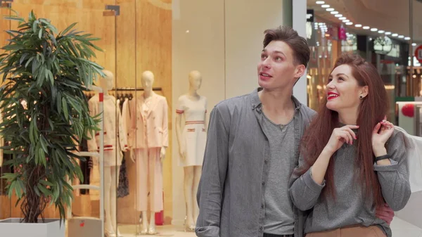 Young couple walking at the shopping mall, enjoying seasonal sales — Stock Photo, Image