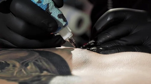 Επαγγελματική tattooist κάνοντας ένα τατουάζ στο στήθος του πελάτη του — Φωτογραφία Αρχείου