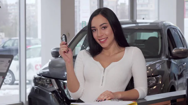 Schöne Frau lächelt, hält ihre Autoschlüssel hoch, nachdem sie ein neues Auto gekauft hat — Stockfoto