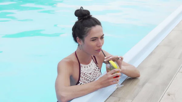 Mulher feliz bonita desfrutando de coquetel na piscina — Fotografia de Stock