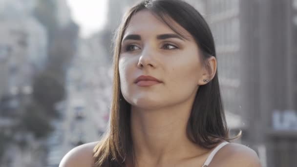 Hermosa mujer mirando hacia otro lado mientras espera a alguien para reunirse en la ciudad — Vídeos de Stock