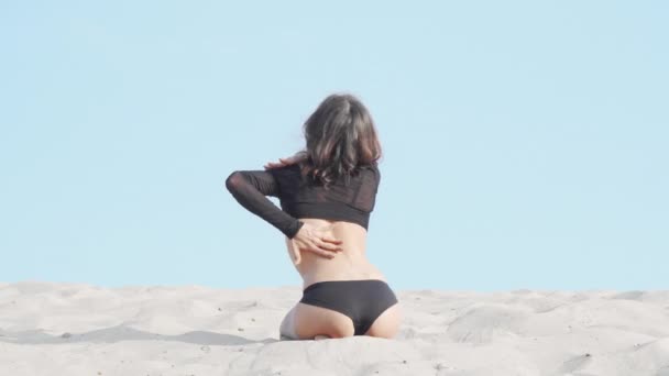 Bailarina femenina delgada de cabello oscuro actuando al aire libre en el desierto — Vídeo de stock