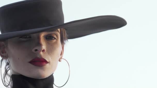 Πανέμορφο κόκκινο χείλη γυναίκα φορώντας μαύρο καπέλο κοιτάζοντας μακριά προσεκτικά — Αρχείο Βίντεο