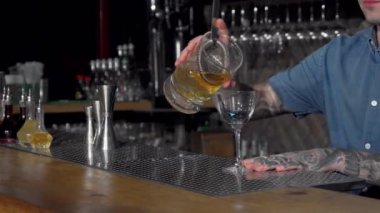 Batender bardağa kokteyl döküyor.