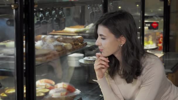 Mooie jonge vrouw glimlachend naar de camera tijdens het winkelen bij de bakkerij — Stockvideo
