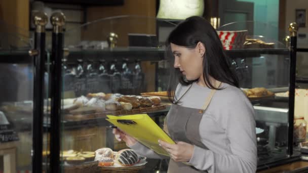 Ung kvindelig bager arbejder i hendes butik – Stock-video