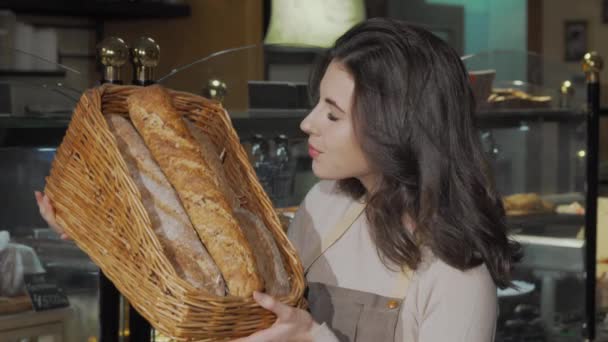Bella donna panettiere odore delizioso pane fresco che vende al suo panificio — Video Stock
