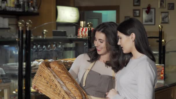 Charmante vrouwelijke bakker die heerlijk brood verkoopt aan haar klant — Stockvideo