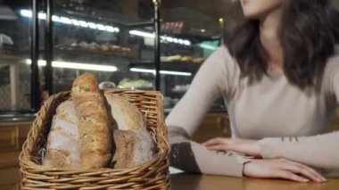 Güzel bir kadın fırında taze ekmek kokusu alıyor.