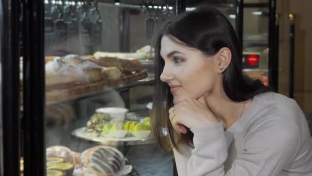 Charmante jeune femme souriant à la caméra tout en faisant du shopping à la boulangerie — Video