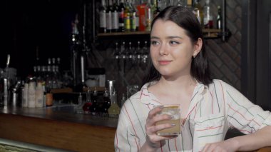 Güzel bir kadın yerel barda içkisini içiyor.
