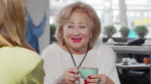 Sevgili son sınıf öğrencisi bir fincan çay eşliğinde kızıyla konuşurken gülüyor.