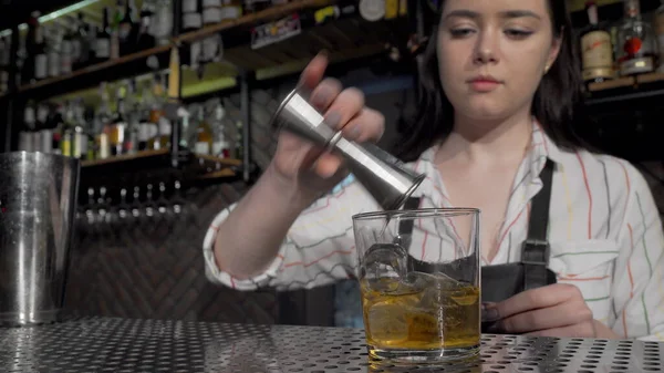 Vrouwelijke barman die cocktails maakt terwijl hij aan de bar werkt — Stockfoto