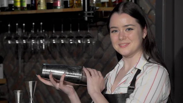 Fröhliche Barkeeperin bereitet einem Kunden ein Getränk zu — Stockfoto