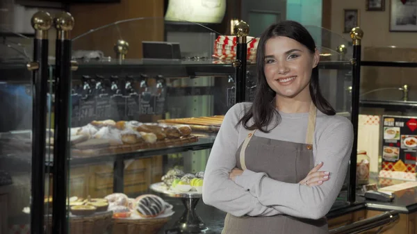 Gururlu genç fırıncı kendi fırınında çalışıyor.