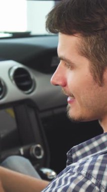 Yakından çekilen bir fotoğraf çekici bir gülümseme ile yakışıklı genç bir adamı yakalar, üstü açık, şık arabasının içinde oturur, akıllı telefonuyla neşeyle meşgul olur. Bu canlı sahne heyecan ve özgürlük yayıyor, modern dünyanın heyecanını vurguluyor.