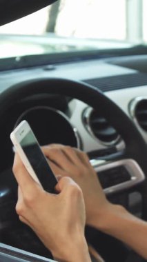 Yakından çekilen bir fotoğrafta yakışıklı genç bir adam üstü açık arabasının direksiyonunu sıkıca kavrıyor ve akıllı telefonuyla uğraşırken neşeyle parlıyor. Bu canlı sahne heyecan ve özgürlük yayıyor, araba sürmenin heyecanını vurguluyor.