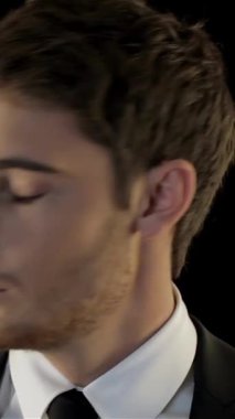 Keskin siyah takım elbiseli kararlı bir genç dürbünle ufku yoğun bir şekilde tarar. Bir amaç ve entrika hissini somutlaştırır. Giyim tarzının ince çizgileri, esrarengiz havayı yükselterek, karanlık arka plana çarpıcı bir şekilde karşı koyuyor.