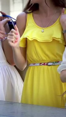 Her biri canlı alışveriş torbaları taşıyan üç modaya uygun kız kahkaha ve heyecanı paylaşarak büyüleyici yeni elbiselerine bayılıyorlar. Işıl ışıl gülüşleri ve neşeli enerjileri canlı bir dostluk ve eğlence ortamı yaratıyor.