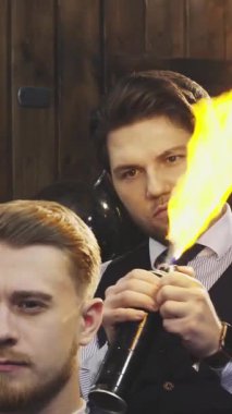 Yetenekli bir berber, müşterilerinin saçlarına dramatik bir yangın tedavisi uygular ve berber dükkanında heyecan verici bir atmosfer yaratır. Bu cüretkar teknik sadece saç stilini değil aynı zamanda sanatın ve cesaretin de altını çiziyor.