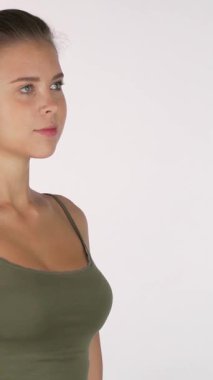 Huzurlu genç bir kadın zarif bir şekilde ayakta duruyor, elleri dua pozisyonunda, odaklanmış bakışları meditasyona hazırlanırken kameraya bakıyor. Atletik fiziği ve sakin tavrı sükuneti yansıtıyor, farkındalığın özünü ve iç dünyasını somutlaştırıyor.