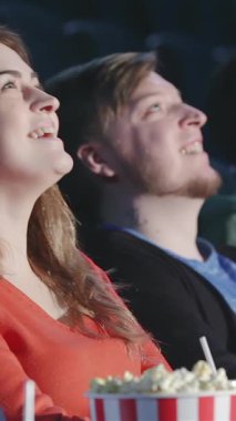 Sıcak bir multiplex tiyatrosunda, iki arkadaş filmin sihrinde kaybolur, yüzleri saf neşe ve heyecanla aydınlanır. Elinde bir kova patlamış mısır ve ışıl ışıl gülücüklerle, bu canlı sahne arkadaşlığın heyecanını ve