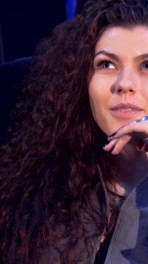 İki neşeli Kafkasyalı kız hareketli bir şekilde düşüncelerini sinemada paylaşıyorlar, bir kıvırcık saçlı güzellik öne çıkıyor, gözleri heyecan ve kahkaha ile parıldıyor. Sıcak ortam tereyağlı patlamış mısır aromasıyla dolu.