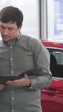 Neşeli, olgun bir çift, galeride göz kamaştırıcı parlak arabaların arasında parlak bir kitapçığa gömülmüş, yan yana durur. Paylaştıkları heyecan ve şefkat, seçtikleri heyecan verici yolculuğa çıkarken parlıyor.