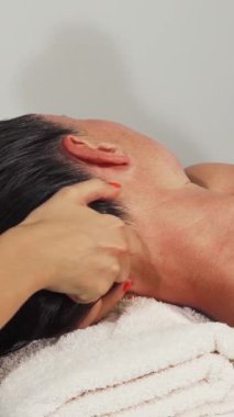 Büyüleyici bir sahne, sakin bir mutlulukta, sakin bir kafa masajından zevk alan olgun bir kadının saçlarının hafif, sıcak bir ışık altında parıldadığını gösteriyor. Bu lüks spa deneyimi huzur ve özgüven yayıyor, izleyicileri kucaklamaya çağırıyor.