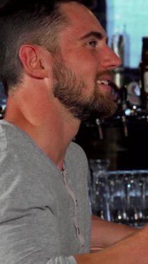 İki neşeli erkek arkadaş, barda heyecan verici bir futbol maçına dalmışken kahkaha ve heyecanı paylaşıyor. Her biri soğuk bir bardak birayı kavramış. Parlak atmosfer yoldaşlık ve neşe ile uğulduyor. Unutulmaz bir gece yaratıyor.