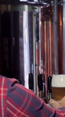 Yakışıklı sakallı bir barmen, keyifli bir anı müşterisiyle paylaşırken altından ve köpüklü bir biradan zevk alır. O da neşeli bir kadeh kaldırır. Bu canlı bar sahnesi sıcaklığı ve dostluğu yansıtıyor, canlı bir ruhun şenlik ruhunu somutlaştırıyor.