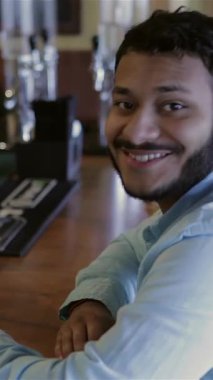 Canlı bir tepede, biri sakallı, diğeri de şık bir ekose gömlekli iki neşeli genç adam sergileniyor. Sıcak bir barda buzlu bira eşliğinde yürekten kahkahalar atıyorlar. Bu canlı sahne, dostluk ve kutlamaya ışık saçıyor.