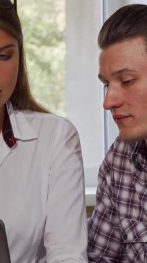 Neşeli bir çift iş arkadaşı güneş ışığındaki bir ofiste dizüstü bilgisayarla iş birliği yaparak takım çalışmasının ruhunu somutlaştırırken pozitiflik yayıyor. Bu ilgi çekici sahnede yakışıklı genç bir işadamı ve onun güzel iş arkadaşı var.