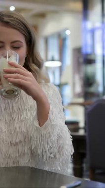 Parlak bir gülümsemesi olan ışıl ışıl bir kadın sıcak ve davetkar bir ambiyansla kaplanmış, sıcacık bir fırının ahşap masasında kremalı kahvesinin tadını çıkarıyor. Taze pişmiş hamur işlerinin nefis kokusu havayı doldurur ve mükemmel bir sabah inzivası yaratır.