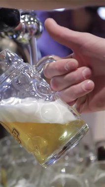 A talented male bartender pours a golden lager into a chilled glass, crafting a perfect frothy head that promises refreshment. The lively bar atmosphere buzzes with excitement, inviting patrons to savor this delightful drink and celebrate the moment
