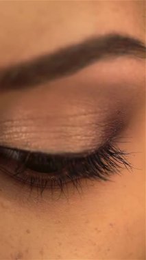 A stunning close-up captures the enchanting gaze of a young girl, her expressive brown eyes reflecting a tapestry of emotions and beauty. Framed by delicate makeup, her radiant features radiate confidence and joy, celebrating the richness of her