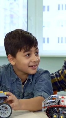 A charming brunette father and his adorable son share laughter while playing with colorful toy SUVs on a bright table, illuminated by natural light streaming through the window. The handsome African American man engages his playful child with funny