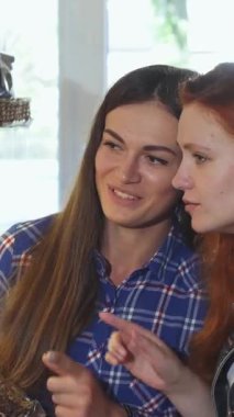 Taze pişmiş malların tatlı aromasıyla dolu sıcacık bir fırında, canlı saçlı iki genç kadın heyecan verici bir kurabiye gösterisinden heyecanlı bir şekilde seçiyorlar. Gülüşleri ve paylaşılan gülümsemeleri keyifli bir atmosfer yaratır.