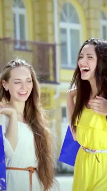 Neşeden patlayan üç ışıl ışıl genç kadın, güneşli bir caddede ellerinde neşeyle sallanan renkli alışveriş torbalarıyla dolaşıyorlar. Gülüşler havada dans eder, keyifli anları paylaşırlar, kaygısız dostluk ve moda ruhunu somutlaştırırlar.