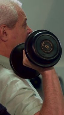 Kendini işine adamış genç bir Kafkas antrenörü kıdemli bir müşteriye temel desteği sağlayarak, formundaki ağırlıkları kaldırırken güç antrenmanı sırasında mükemmel olmasını sağlıyor. Yakından çekilen görüntüler yaşlı adamların odaklanmış ifadesini gösteriyor.