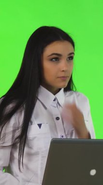 Uzun siyah saçlı odaklanmış genç bir iş kadını, parlak gümüş bir dizüstü bilgisayarda yazarken nazikçe çenesini eline dayayarak bir sonraki büyük fikrini düşünüyor. Canlı yeşil bir zemin üzerine kurulmuş bu dinamik sahne yaratıcılık ve hırs yayıyor.