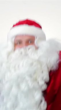 A lively Santa Claus dances with infectious joy against a crisp white backdrop, exuding the warmth and cheer of the holiday season. His vibrant red suit and fluffy white beard create a captivating scene, embodying the spirit of Christmas celebrations