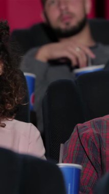 A young couple snuggled in plush theater seats, sharing laughter and excitement as they immerse themselves in a captivating film. With popcorn in hand and the glow of the screen illuminating their faces, they embody the joy and warmth of a perfect