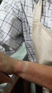 A cheerful young male shoemaker radiates happiness as he lovingly polishes stunning handmade shoes in his warm and inviting workshop. This captivating scene beautifully highlights the dedication and artistry of craftsmanship, where each shoe tells a